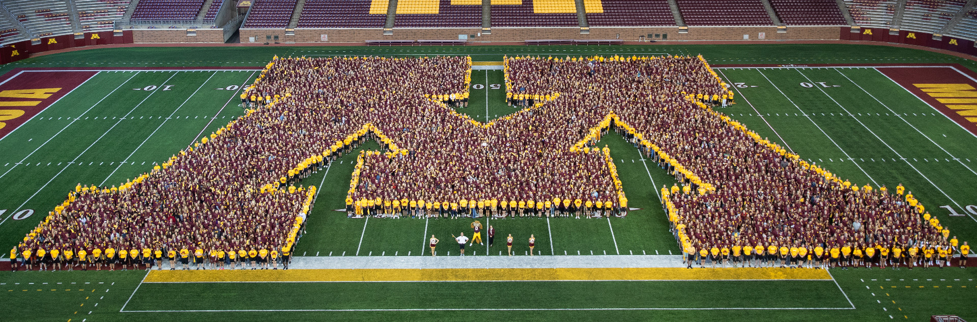 2019 University of Minensota Freshmen create a Block M on the football field with the marching band and welcome week leaders