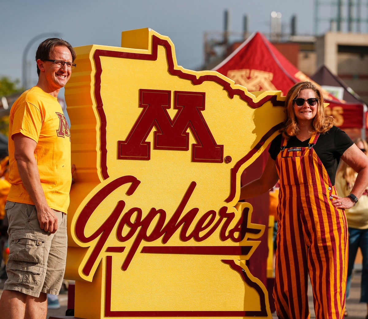 Parents in front of the M Gophers state sign